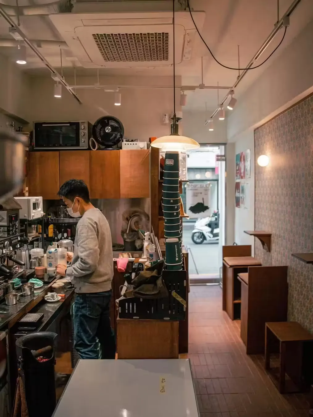 barista working at espresso machine in narrow café interior with wooden furnishings., sim coffee house, seoul