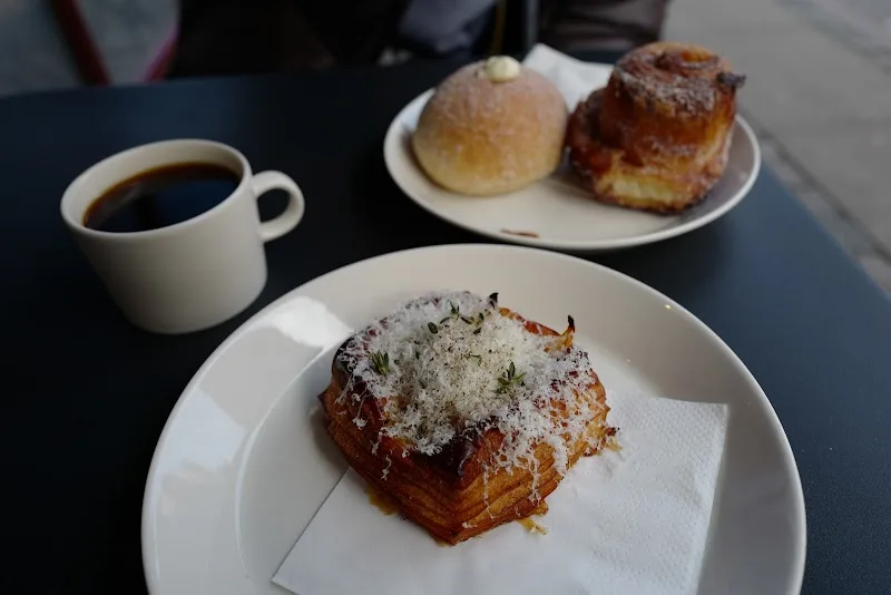 black coffee, croissant with powdered sugar and herbs, pastries on white plates., sinne gas bageri, copenhagen