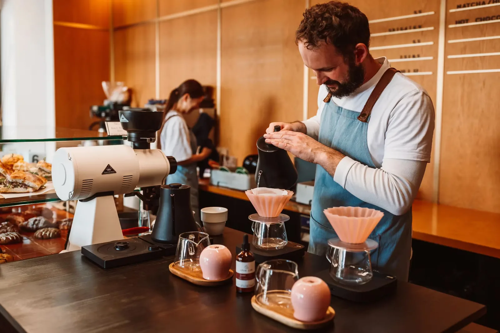 barista pouring filter coffee with precision equipment and pink pour-over cones., sketchbook coffee, wellington