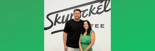 two people standing in front of skyrocket coffee branded backdrop wall., skyrocket coffee, austin