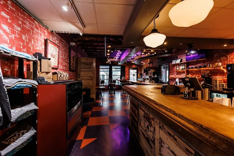 modern bar interior with red brick walls and wooden counter seating., smelly cat coffee house & roastery, charlotte