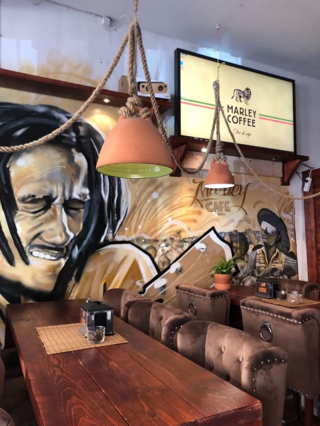 marley coffee café interior with rope pendant lamps and reggae-themed wall art., söder marley cafe, stockholm