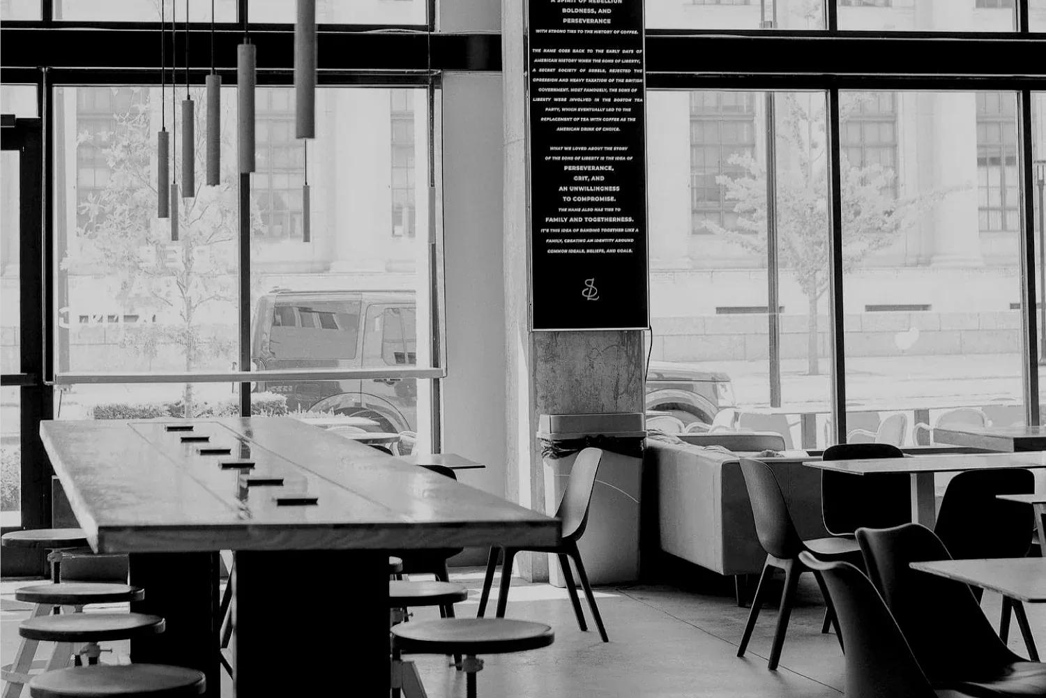 modern cafeteria with floor-to-ceiling windows, minimal furniture, and inspirational wall text., sons coffee, fort worth