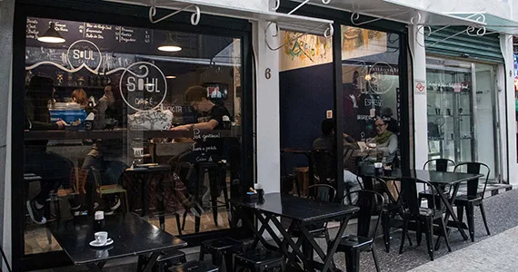 storefront café with large windows, customers inside, bicycles parked outside, modern urban setting., soul café sp, são paulo