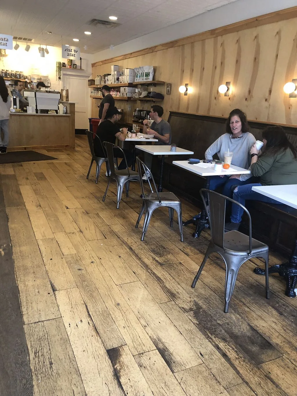 café interior with customers seated at tables, wooden floors and walls, counter service., southdown coffee, huntington