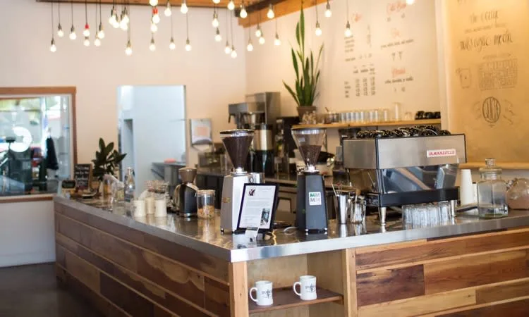 modern coffee shop counter with espresso machines, grinder, plants, and pendant lighting., spearhead coffee, paso robles