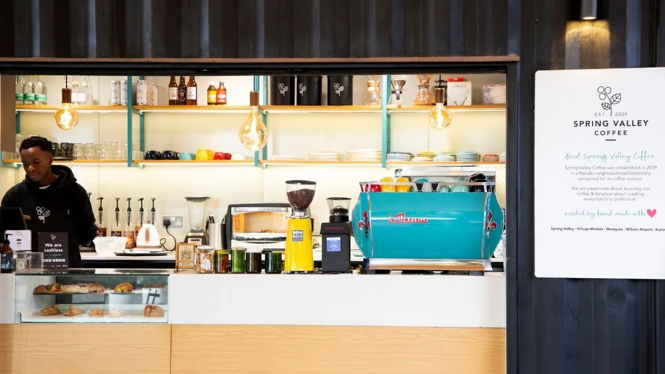 spring valley coffee shop counter with turquoise espresso machine and illuminated shelving., spring valley coffee @ spring va