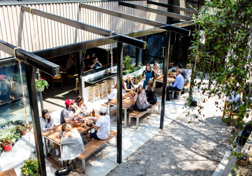 outdoor covered dining area with people eating at wooden tables and benches., streat cromwell cafe, collingwood