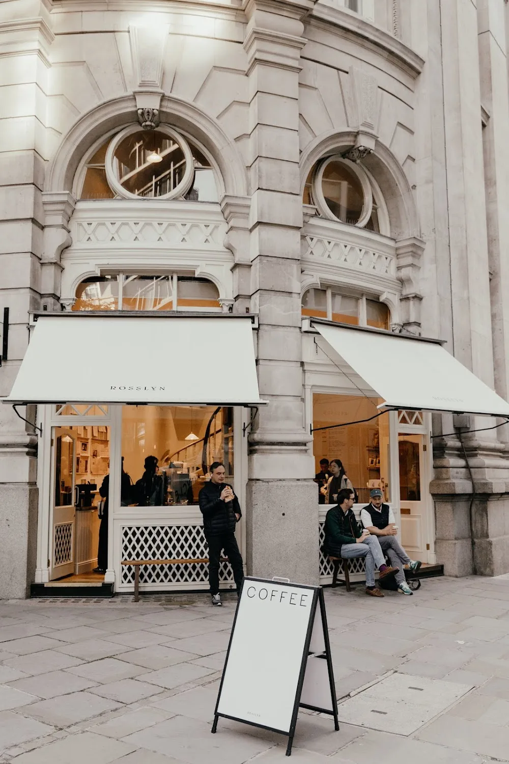 modern coffee shop storefront with elegant architecture and outdoor seating area., t4 liverpool street, london