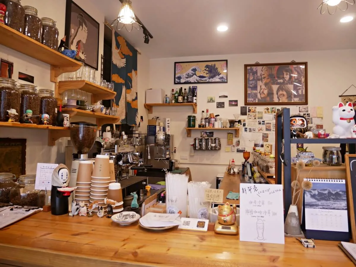 cluttered japanese-inspired coffee shop counter with espresso machine and memorabilia., takeaway coffee 帶著走咖啡｜咖啡豆專賣｜自家烘焙咖啡, t