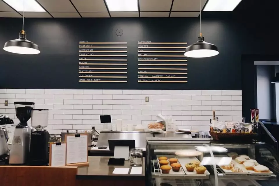 modern coffee shop interior with menu board, espresso equipment, and pastry display case., tapestry coffee, lakeville