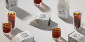 branded beverages arranged with glasses and bottles on white surface with shadows., tea temple, bogotá