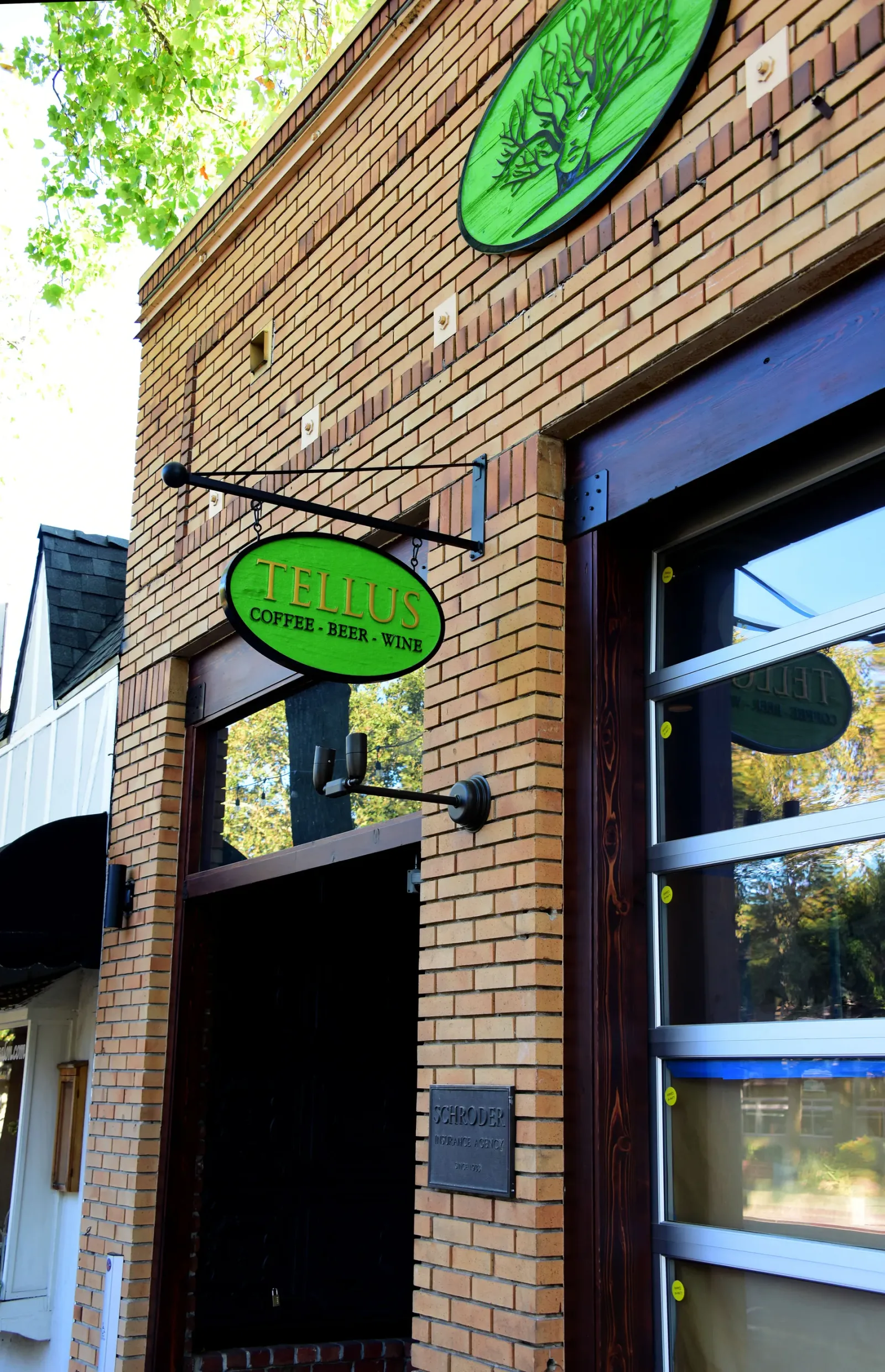 brick storefront with green "telus coffee beer wine" oval sign and hanging bracket., tellus coffee, walnut creek