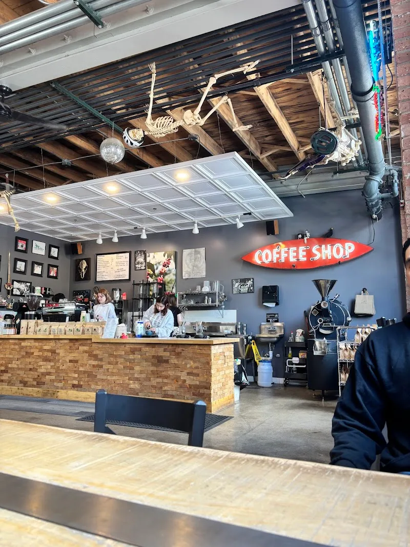 industrial coffee shop with skeleton decoration and retro neon sign overhead., ten drops coffee, chicago