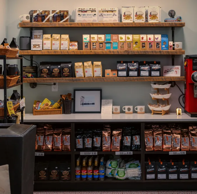 coffee shop retail display with packaged beans, cups, and merchandise on wooden shelves., the butcher shoppe / big oak cafe, 