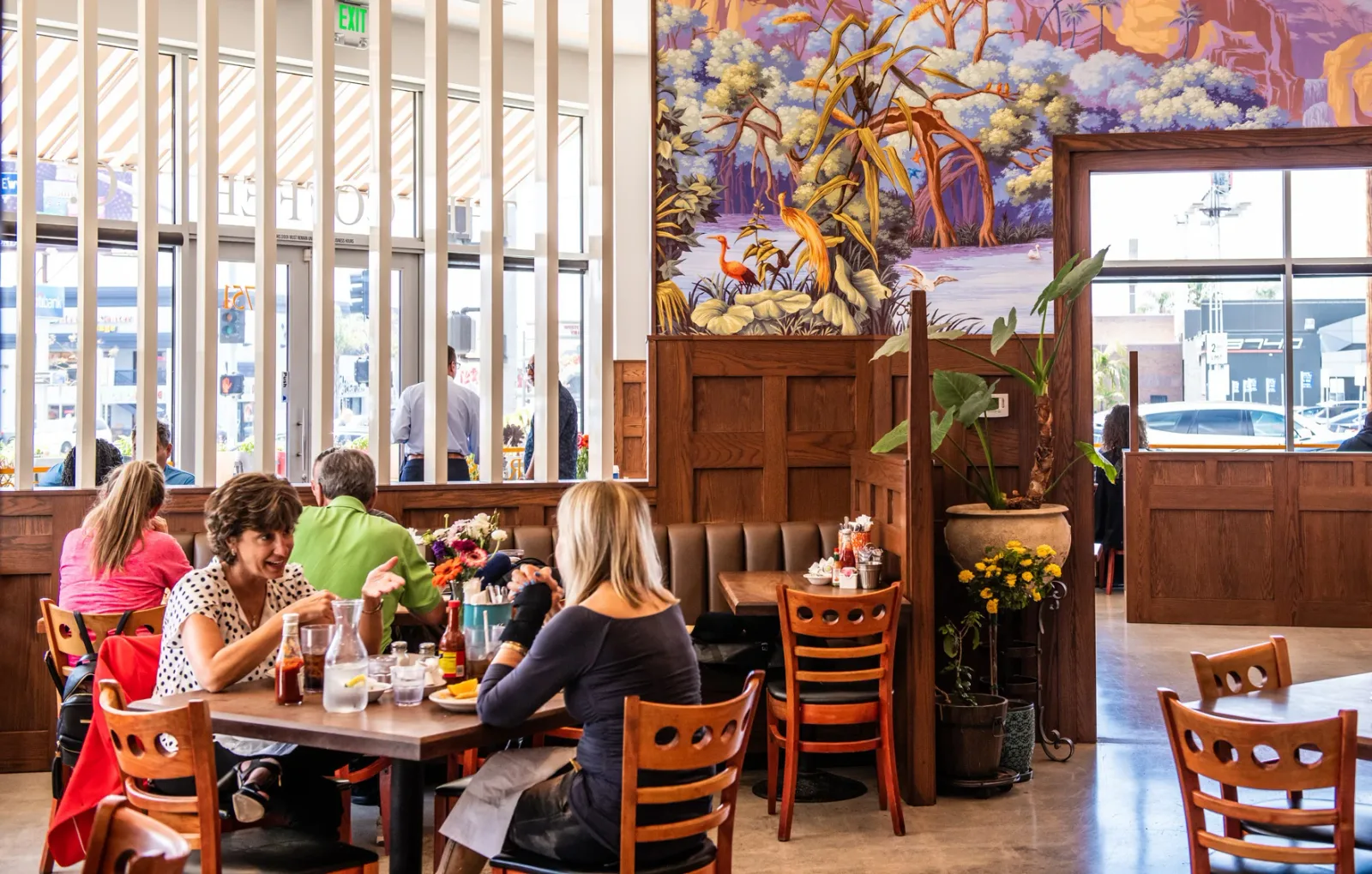 restaurant interior with diners, wood paneling, mural art, and large windows., the coffee company, los angeles
