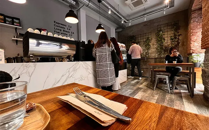modern café interior with wooden counter, marble service bar, and exposed brick walls., the fix - café de especialidad, madri