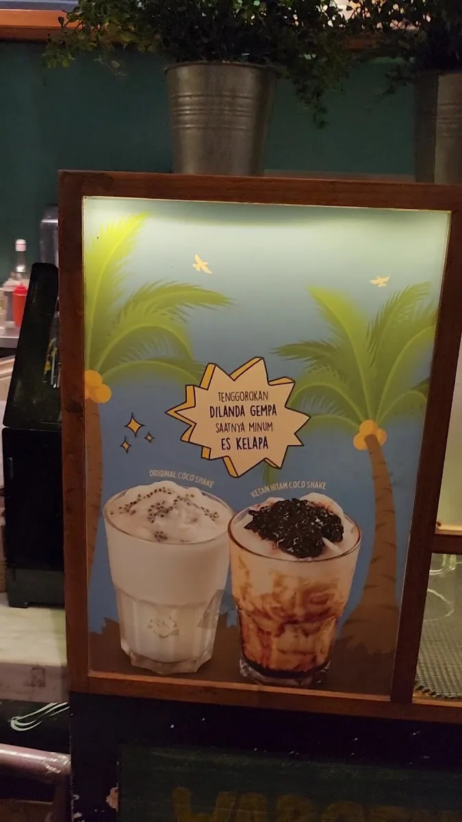 menu board displaying two coco shake beverages with tropical palm tree background design., the people's cafe - central park, 
