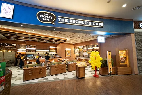 the people's cafe storefront with blue signage, wooden counters, and yellow flower decoration., the people's cafe - central p