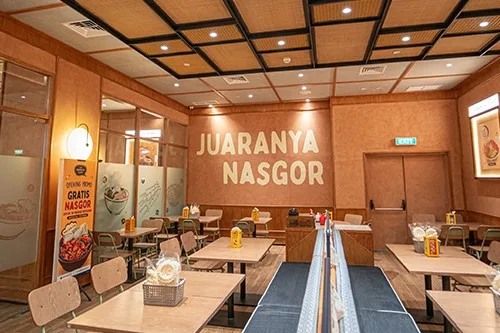 restaurant interior with "juaranya nasgor" signage, dining tables, and warm wooden decor., the people's cafe pacific place, j