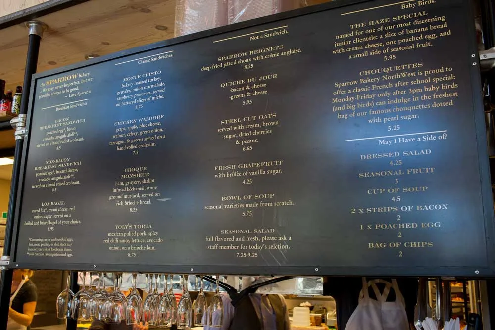 restaurant menu board displaying breakfast items, sandwiches, and beverages with prices., the sparrow bakery northwest, bend