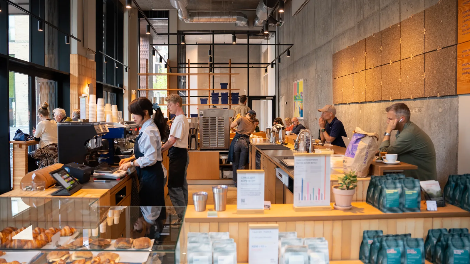 modern coffee shop interior with customers, wooden counters, and industrial design elements., the spot, copenhagen