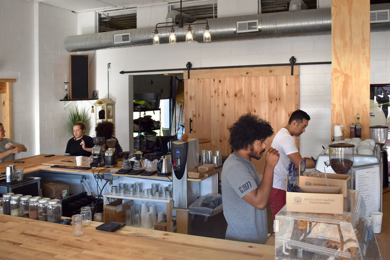 modern coffee shop interior with wooden counter, staff, and industrial ceiling design., three crowns coffee, warsaw