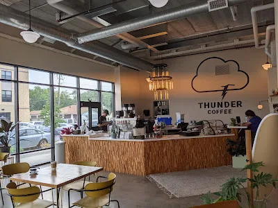 modern coffee shop interior with wooden counter, cloud logo, and large windows., thunder coffee, fargo
