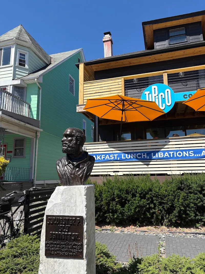 vintage diner with orange umbrella, historic bust statue, colorful residential buildings nearby., tipico coffee & cafe, buffa
