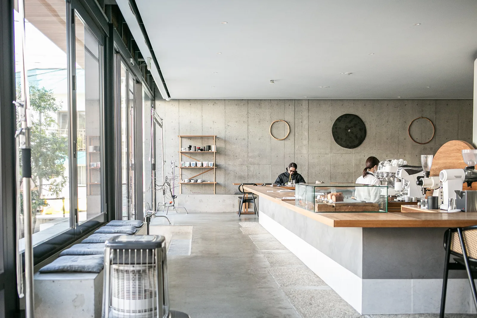modern minimalist cafe with concrete walls, wooden counter, and large windows., tokyo coffee lab., tokyo