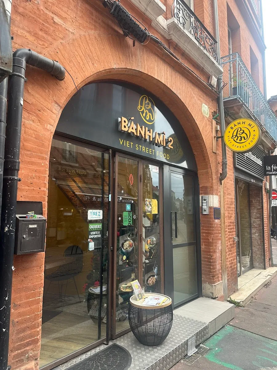 vietnamese street food restaurant storefront with arched brick entrance and yellow signage., toms coffee roasters ridder schw