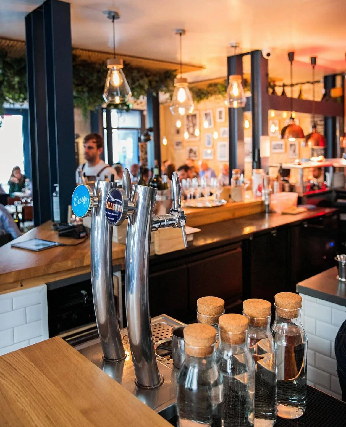 modern bar interior with beer taps, pendant lights, and warm sunset ambiance., tonton des dames, paris