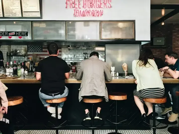 customers seated at counter in casual burger restaurant with pink neon signage., totte para todos, miguel hidalgo, mexico cit
