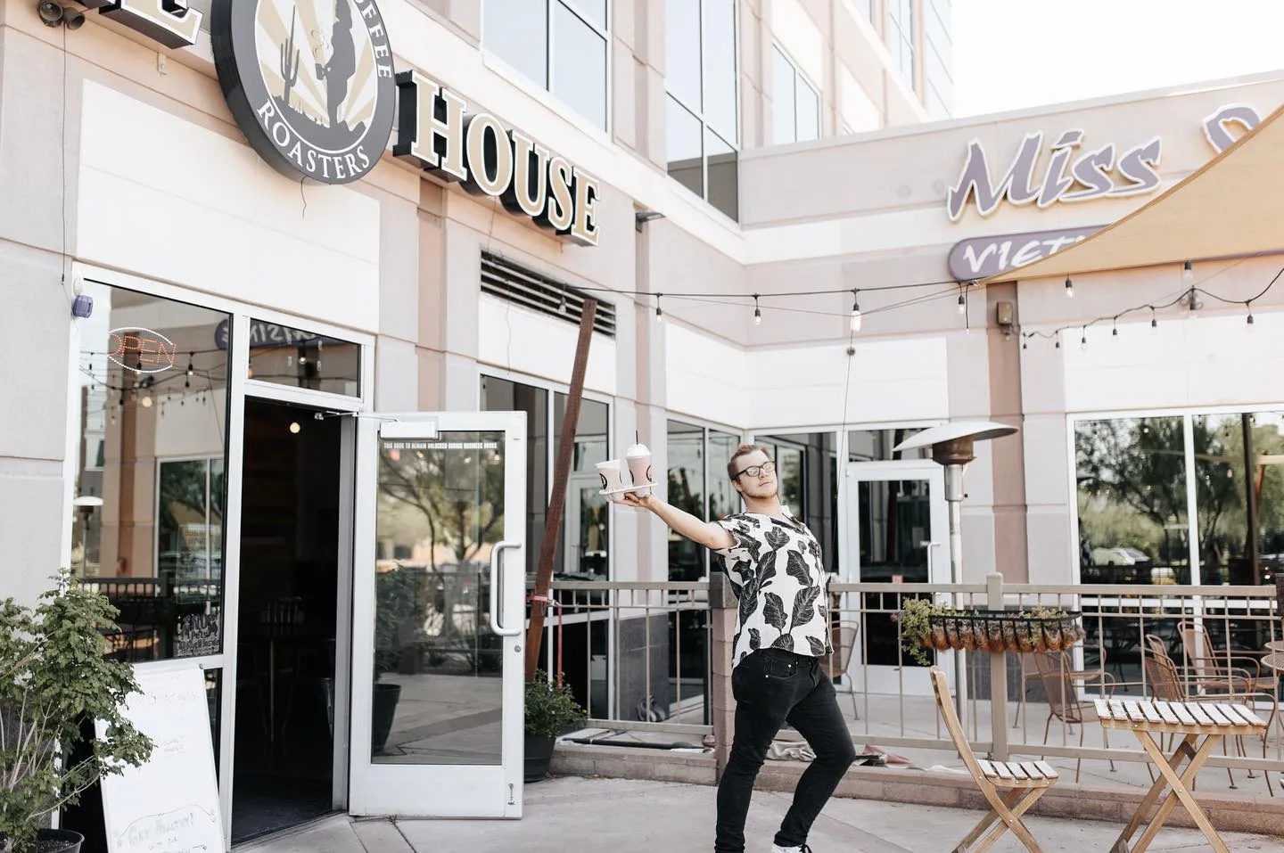 man in patterned shirt juggling outside roastery coffee house storefront., tucson coffee roasters, arizona