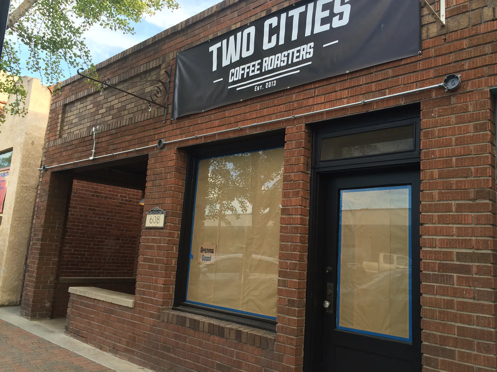 two cities coffee roasters storefront with brick facade and papered windows., two cities coffee roasters, fresno