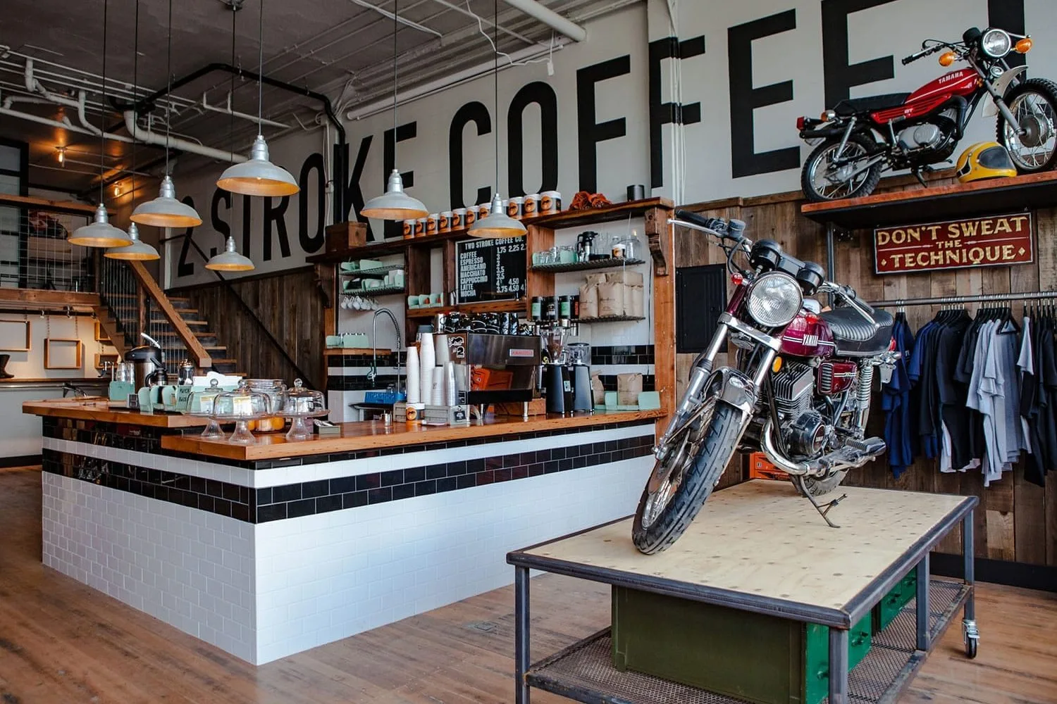 motorcycle-themed coffee shop with bikes, industrial decor, and clothing displays., two stroke coffee co., portland
