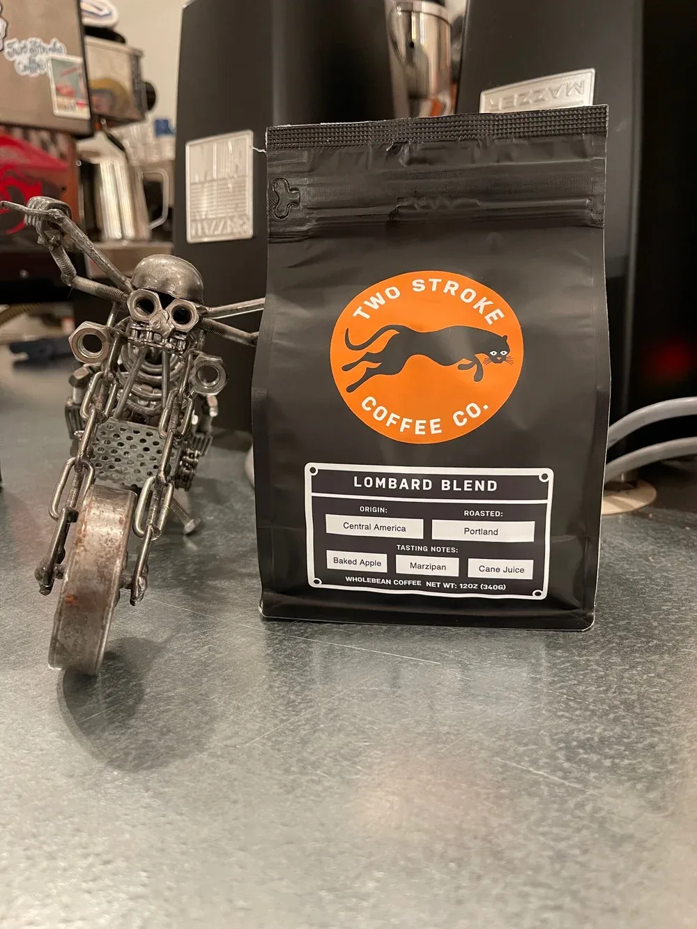 two stroke coffee co. lombard blend bag beside motorcycle engine keychain ornament., two stroke coffee co., portland