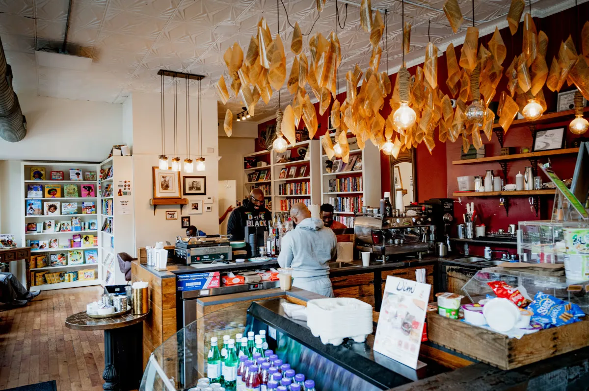 cozy coffee shop with hanging dried flowers, bookshelves, and wooden counter., uncle bobbie's coffee & books, philadelphia