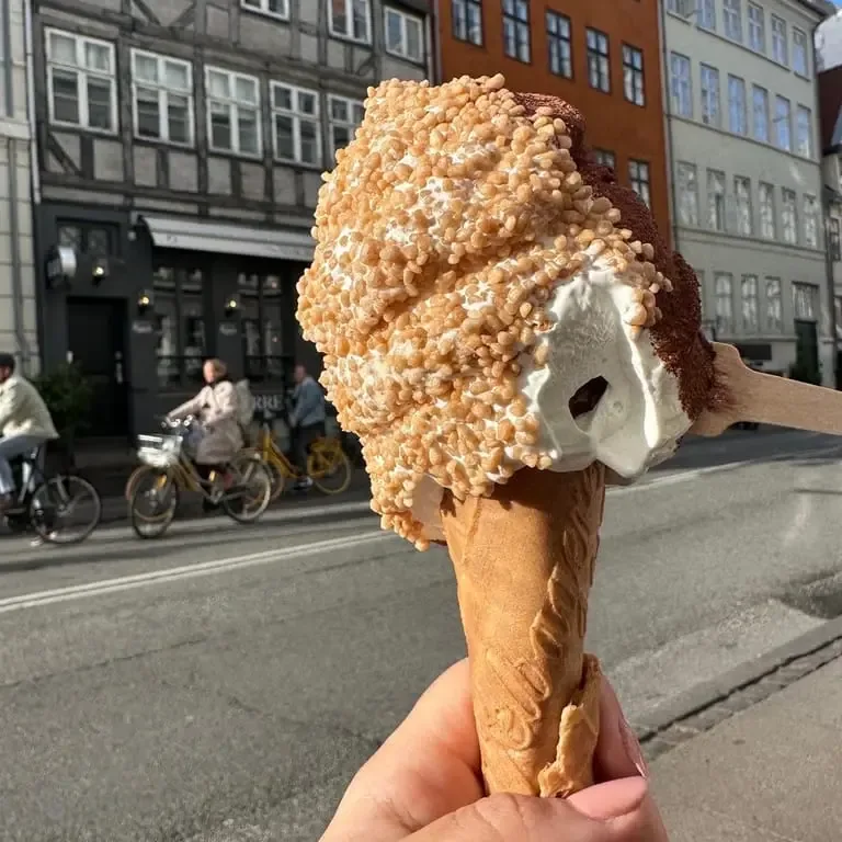 hand holding giant ice cream cone with crispy coating on european street., vaffelbageren nyhavn, copenhagen