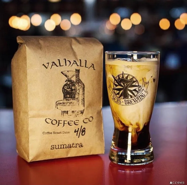 valhalla coffee bag next to iced cold brew in branded glass on bar counter., valhalla coffee co., tacoma