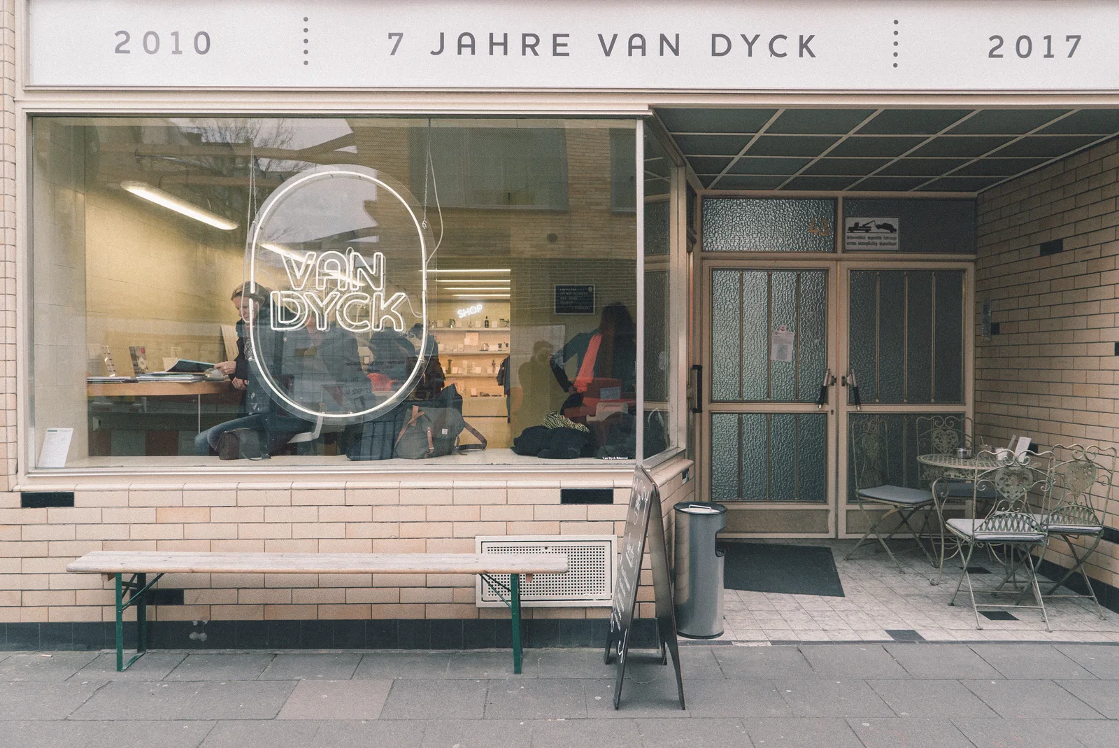 van dyck storefront with neon sign, bench seating, and interior customers visible., van dyck, cologne