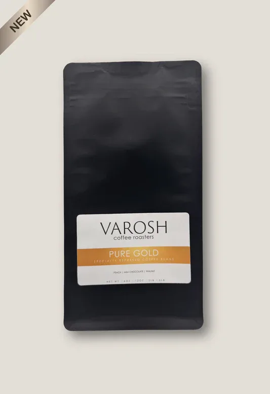 black coffee bag with varosh branding and pure gold label displayed against beige background., varosh coffee roasters, charlo