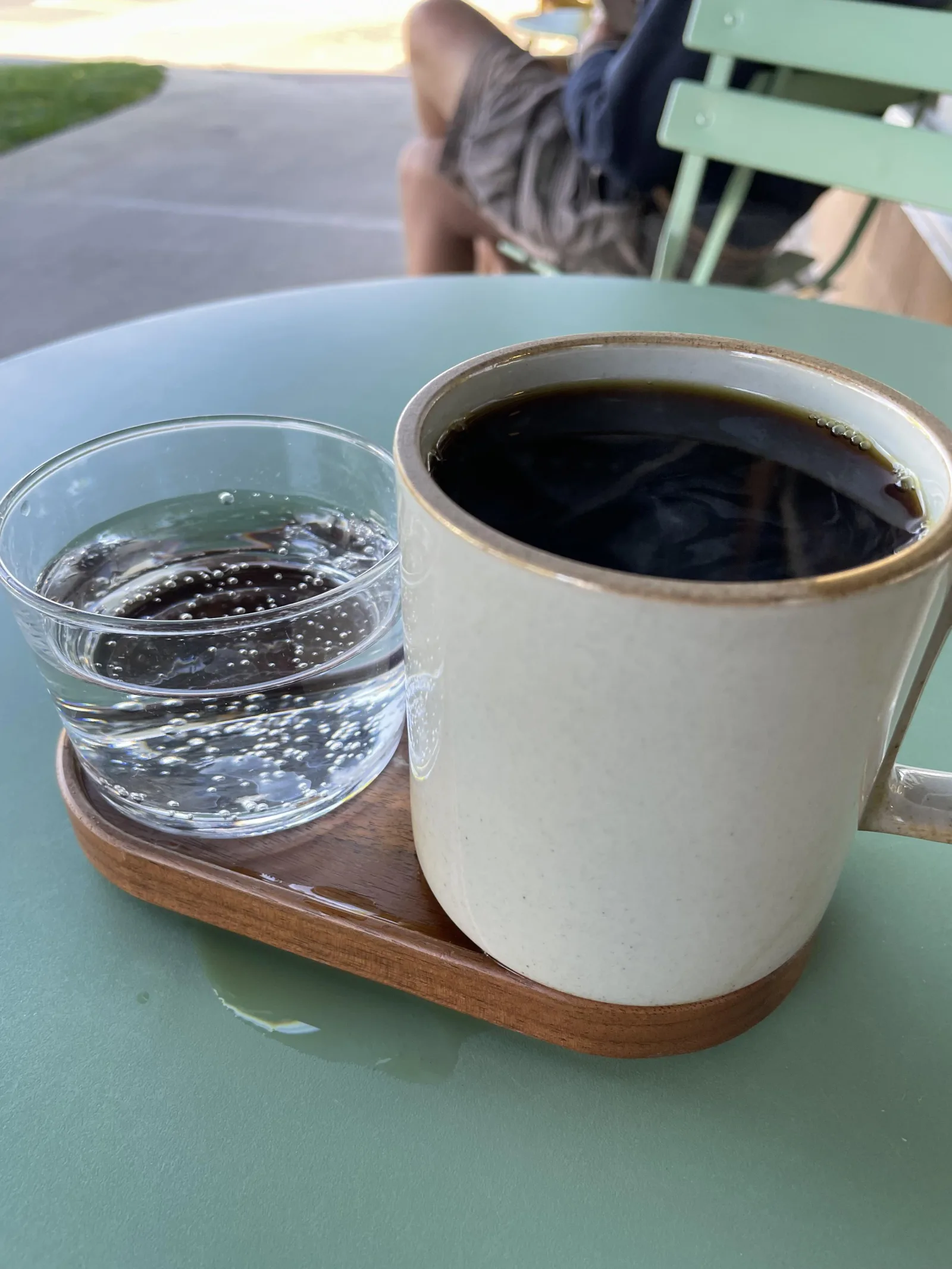 coffee and water served on wooden tray at outdoor table., verb coffee roasters, boulder