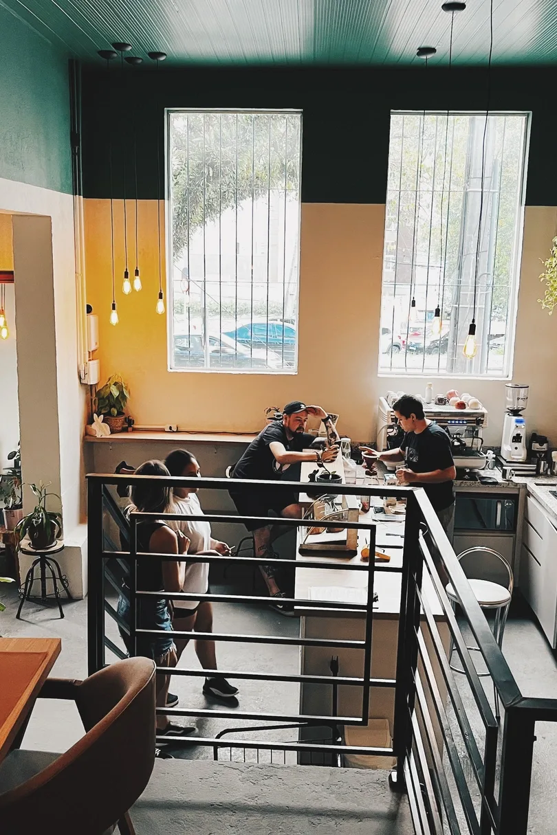 modern café interior with yellow accent wall and customer service counter., verdê cafés - mercês, curitiba