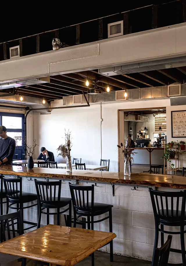 modern cafe interior with bar seating, exposed beams, and minimalist decor., vertex coffee roasters, ann arbor