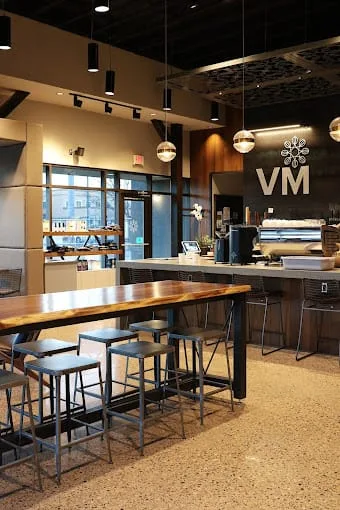 modern office break room with wood table, bar seating, and pendant lighting., villa myriam coffee, albuquerque