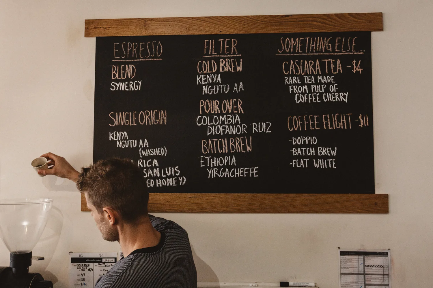man reading coffee shop menu board with espresso, filter, and specialty drink options., villino coffee, hobart
