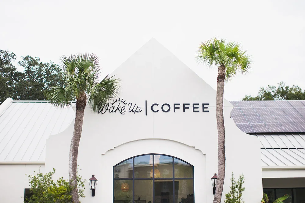 white building with "wake up coffee" sign, palm trees, arched window., wake up coffee company, brunswick