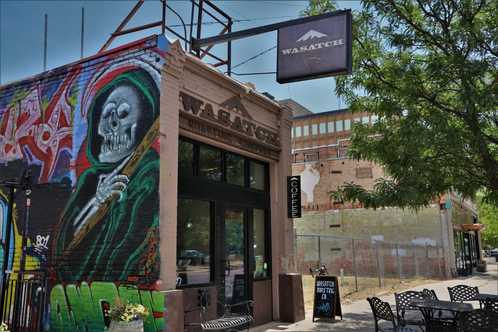 wasatch coffee shop storefront with vibrant skull mural and outdoor seating area., wasatch roasting company, ogden