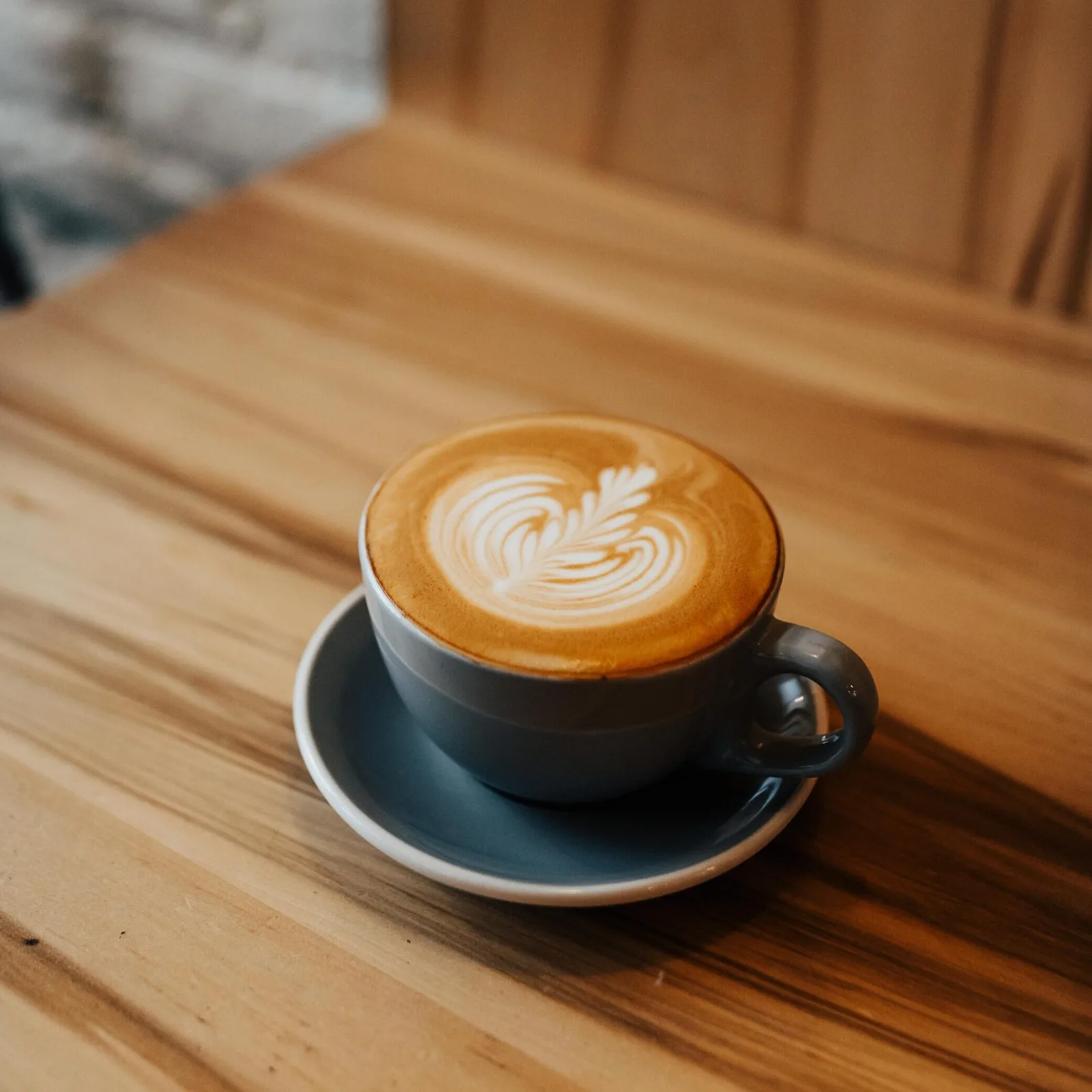 black coffee cup with latte art on wooden table indoors., wasatch roasting company, ogden